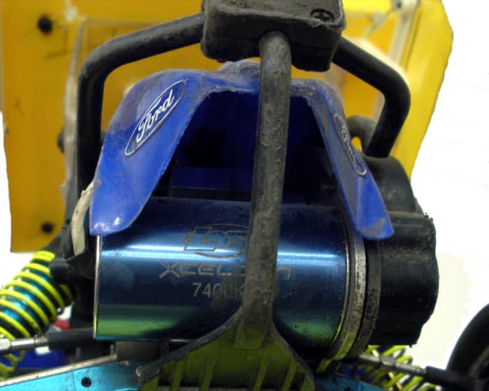 A brushless motor installed in a vehicle. This car is set up for running dirt ovals; note the skid plate and roll cage protecting motor.