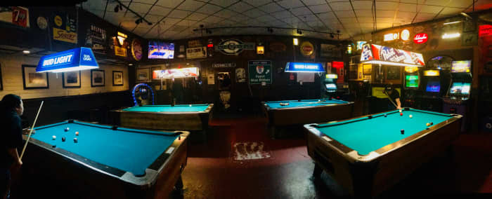My lurking spot is in front of one of the arcade games in the back of the room. There, you can see all of the tables and how many quarters have been placed at each one.