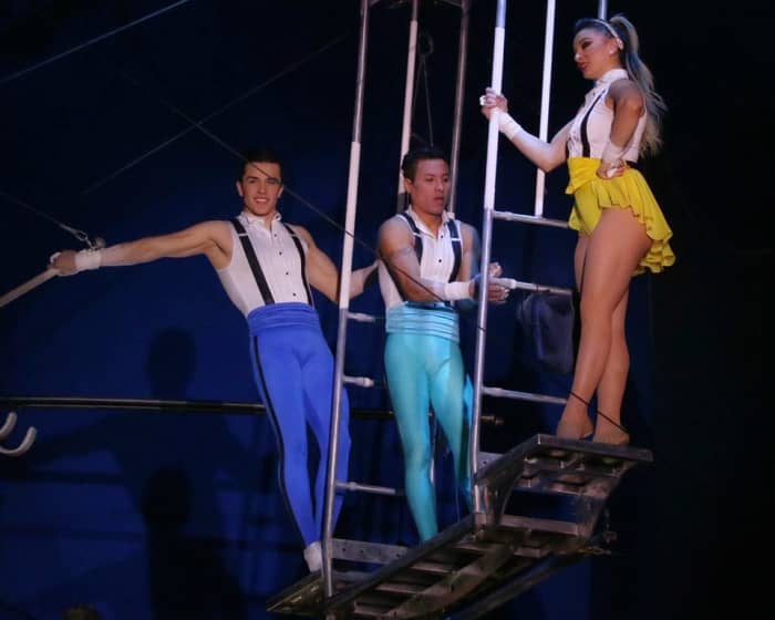 As he prepares to take the bar, Mauricio Navas (center) pats the fabric bag containing smooth, white chalk; Big Apple Circus