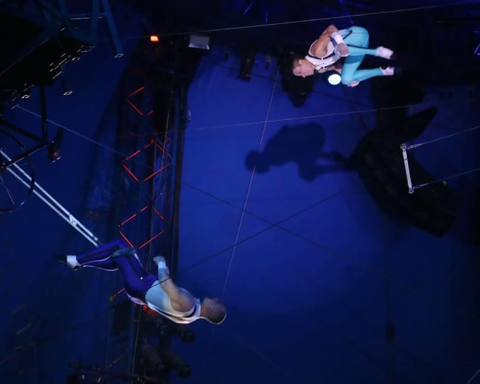 Mauricio Navas turns a somersault toward the arms of catcher Adriano de Quadra; Big Apple Circus