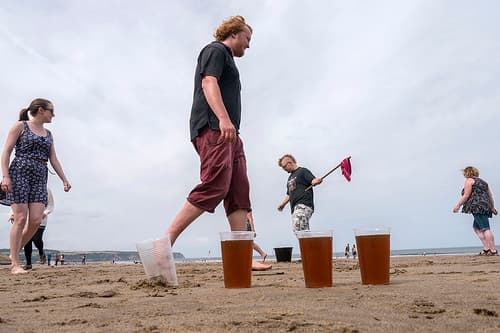 This is dwile flonking. It involves dancing around buckets of beer and avoiding a beer-soaked cloth launched from a stick.
