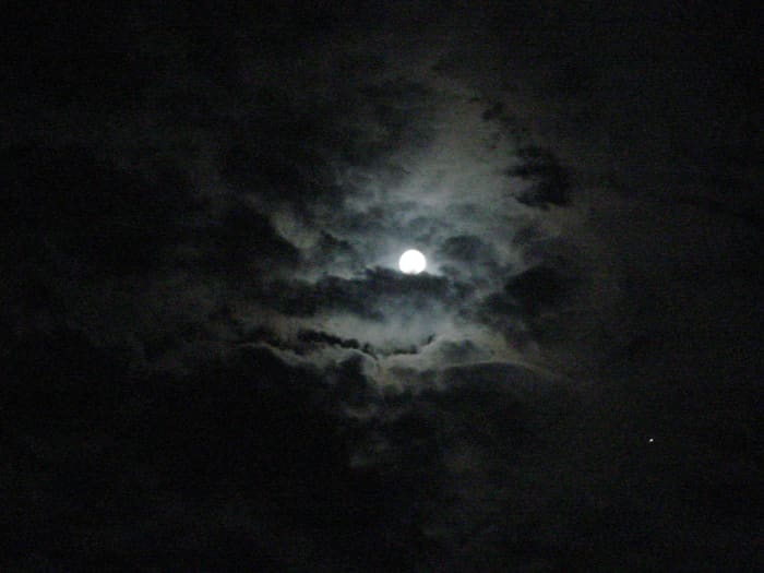 Full moon surrounded by clouds over Carmel-by-the-Sea, California.