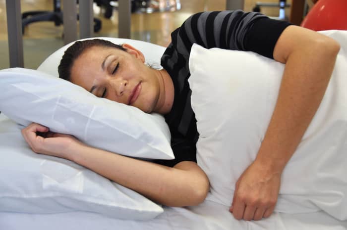 If you are going to sleep on your side, stack your shoulders and hips. Rest your top arm on your side or on pillows.