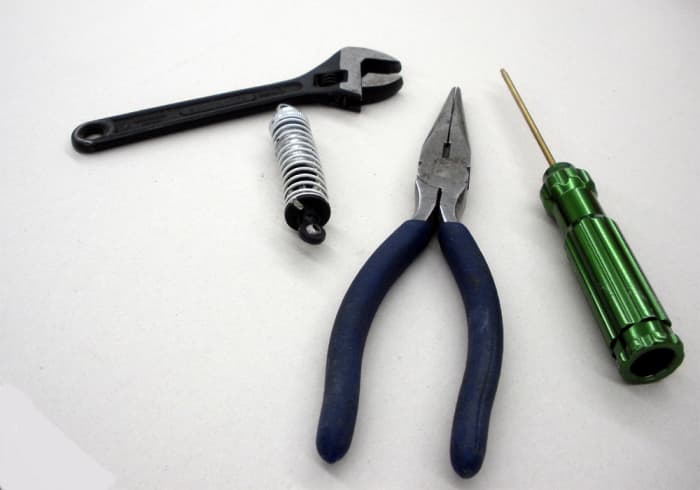 Left to Right: small adjustable wrench; rebuild kit; needle-nose pliers; small screwdriver.