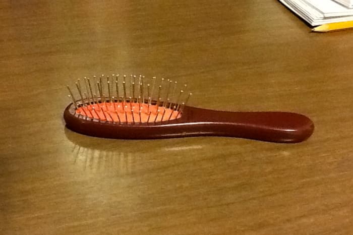 This is an official American Girl doll hairbrush. Note the widely spaced metal bristles that won't snag synthetic hair.