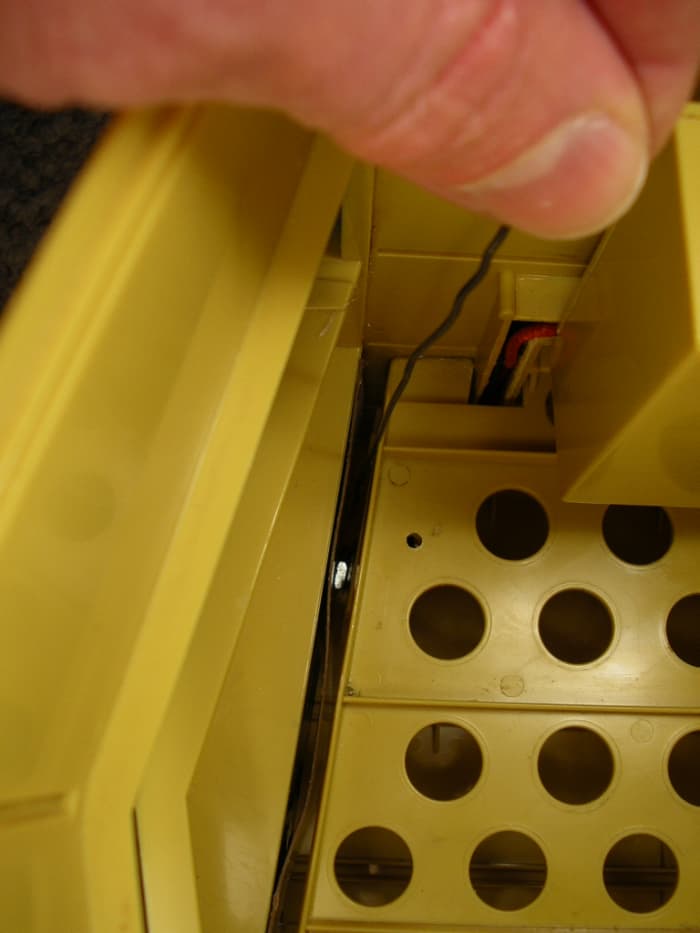 Looking down the left side from the rear of the vehicle. Here, I am using a hooked paperclip to thread on the silver nut.