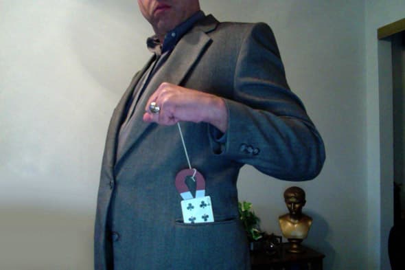 In this card trick, you lower a magnet into your pocket by a string and pull it out with the selected card attached!