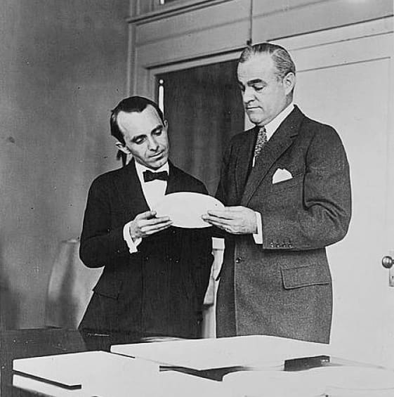 Sculptor Anthony de Francisci (left) and Mint Director Raymond T. Baker (right) inspecting a plaster model of the new silver dollar coin.