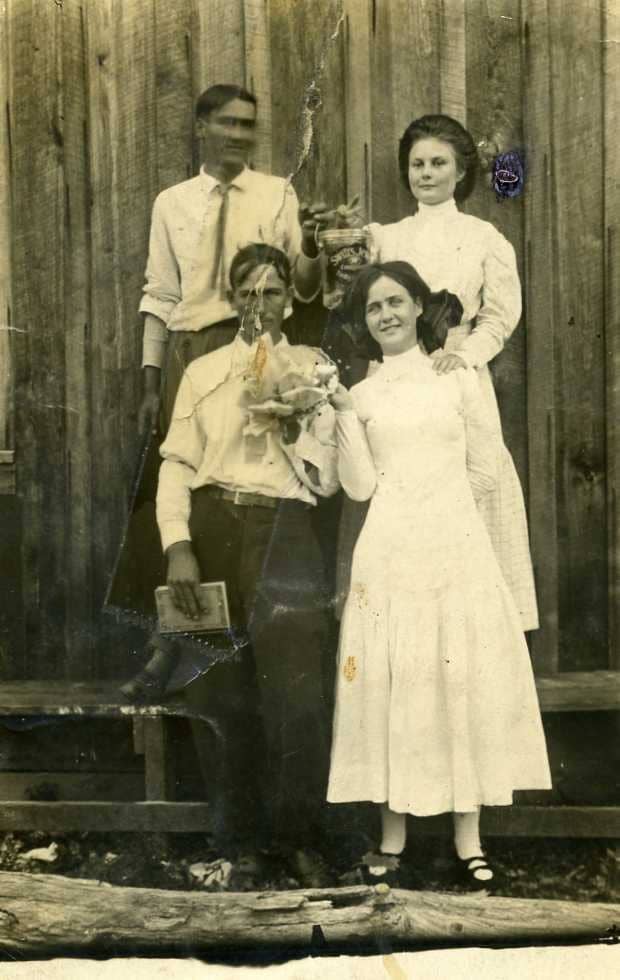 The lovely young lady in the back row is my maternal grandmother. This looks like it may have been taken at a church supper. No family member has been able to identify the other three young people in the photo, but neither man is my grandfather.
