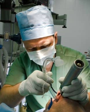 A special lighted scope is used to move the tongue out of the way, see the vocal cords, and place the breathing tube between them.