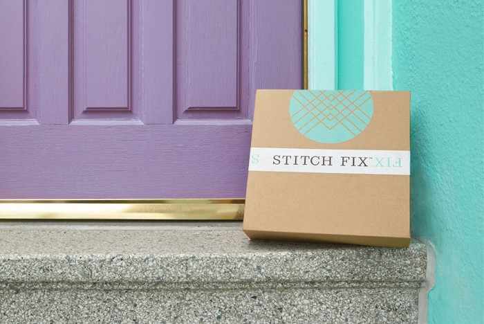 Stitch Fix box waiting at a door with lots of dresses and blouses and pants and goodies inside.