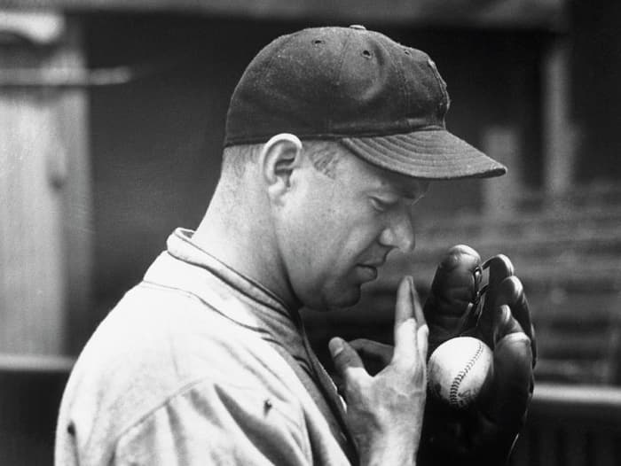 Burleigh Grimes wetting his fingers before launching a spitball pitch. Outlawed by MLB in 1920, the spitball was still allowed to be thrown by 17 pitchers who were exempt from the restriction. In 1934, Grimes was the last to hurl a legal spitball.
