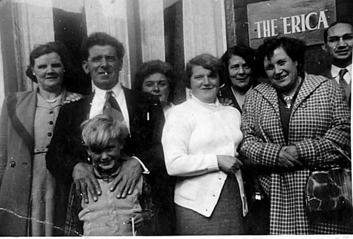 Grandad (second left) and grandma (third left) outside grandma's seaside guesthouse, The Erica, pictured with smiling guests and my brother as a child, in the late 1950s.