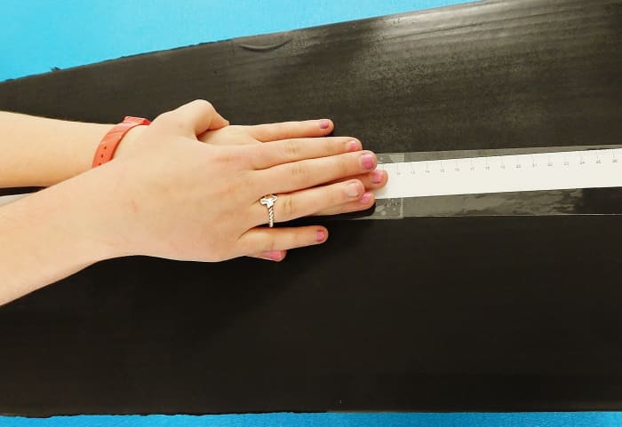 Participants need to put one hand on the other and reach forward as far as they can without bouncing.