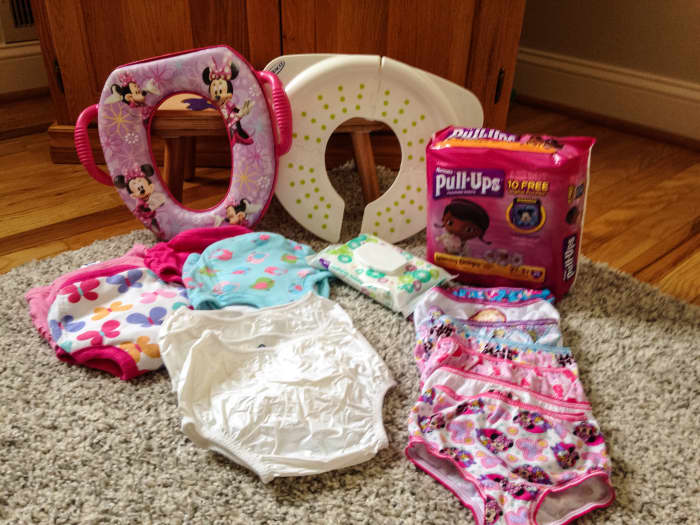 A shot of everything I purchased before potty training; potty seat, folding potty seat, 1 package of Pull Ups, Gerber training pants, flushable toddler wipes, plastic pants, and plenty of underwear.