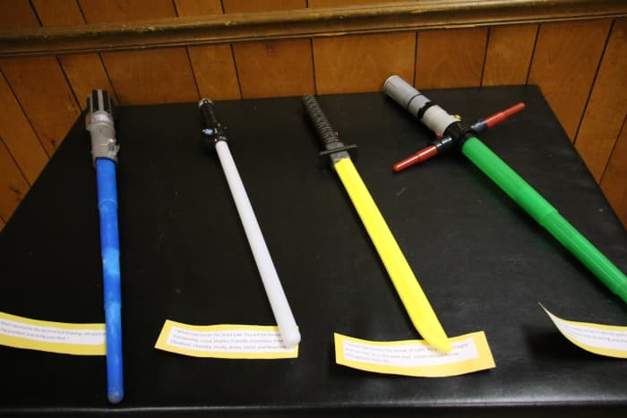 Set out the blue, white, yellow, and green light sabers on a table so they are easily obtained for the Arrow of Light ceremony. Print scripted lines on card stock for adult volunteers to read.