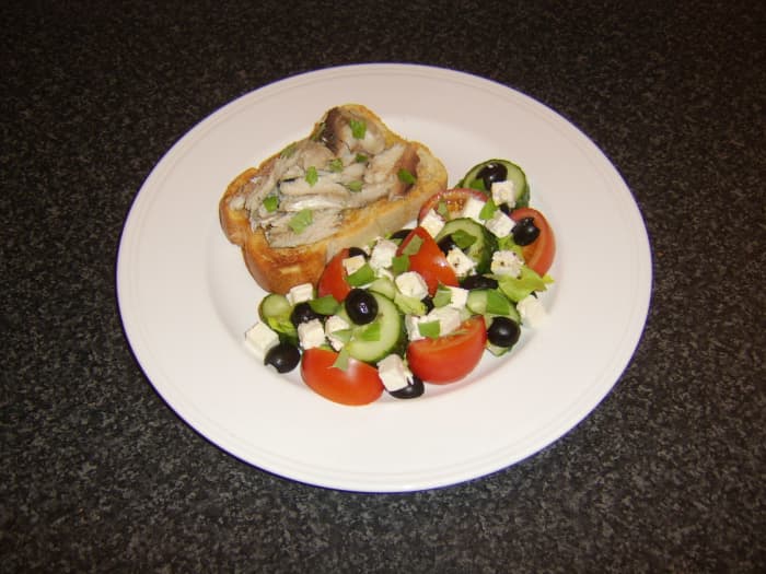 Herring is poached and cooled before the flesh is picked from the bones and it is served on a slice of bruschetta with an accompanying Greek style salad