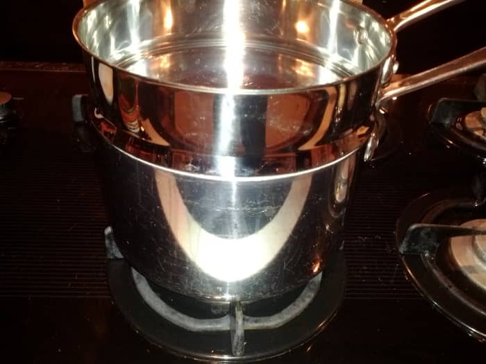 A double boiler has a pot on the bottom with the boiling water and a pot on top to hold the ingredients. The point of the double boiler is to avoid direct heat.