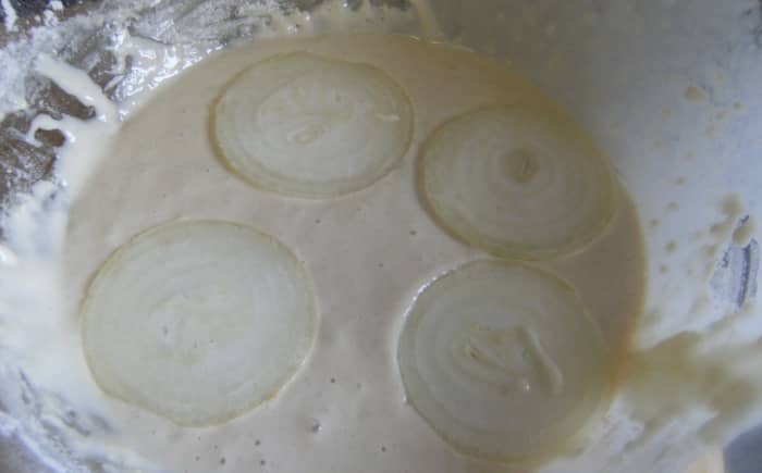 Add a few rings to the batter mix. Turn them over with a fork to cover with the mix.