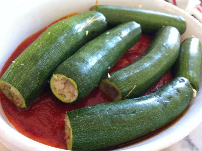 Zucchinis all fit in the dish with the tomato, wine sauce. They're ready to be baked.