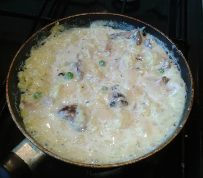 All the ingredients for chicken and mushroom risotto mixed in the saucepan just before serving