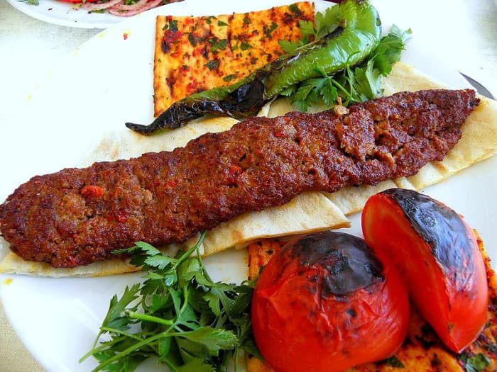 Kebab served with khubz, roasted tomatoes and capsicum and parsley.