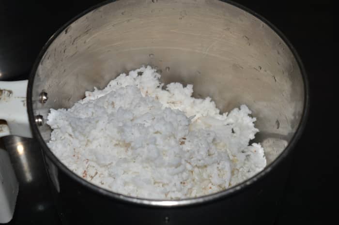 Grind soaked rice, grated coconut, and cardamom to get a very smooth liquid. Add water while grinding.