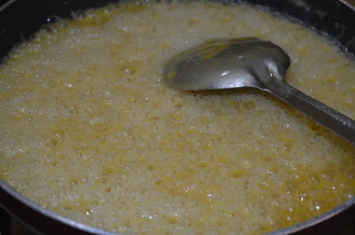 Step 7: Alternate between adding flour and oil until they're all gone. You should see white froth and hear a sizzling sound. The mix absorbs the oil. Stir continuously. Add all the gram flour in batches, and pour the oil in a little bit at a time.