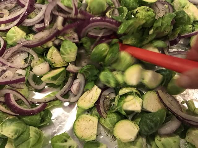 Simple seasonings are best. Salt, freshly cracked black pepper, and garlic powder are all you need for this dish. Use olive oil—not extra-virgin—and drizzle lightly before tossing to combine.