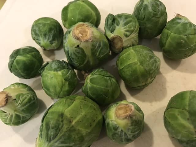 Cut the ends off each sprout, then cut them in half. If any are really big, cut them into quarters. The goal is to have them all about the same size.