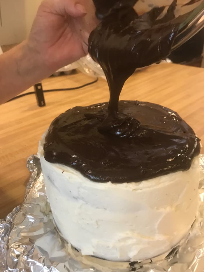 The ganache will pour easily if you use it immediately. Here it is poured over a black velvet cake frosted with simple buttercream.