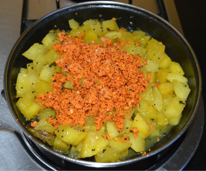 Step six: Add ground coconut masala mixture. Add remaining salt. Gently mix with the other contents in the pan. Keep the heat very low. Once they blend well, turn off the heat.
