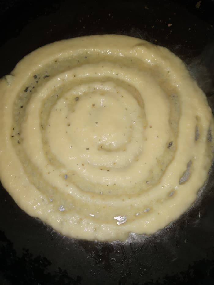 Heat pan and smear on oil or ghee. Add one ladleful of batter. Spread it evenly with the back of the spoon and make a thin dosa.