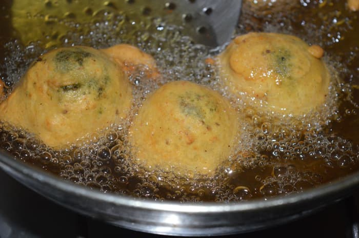 5. Heat the oil for deep-frying. When the oil becomes moderately hot, dip a few balls in the batter and gently slide them into the oil. Don't overcrowd them. Turn them occasionally to ensure uniform cooking on all sides.