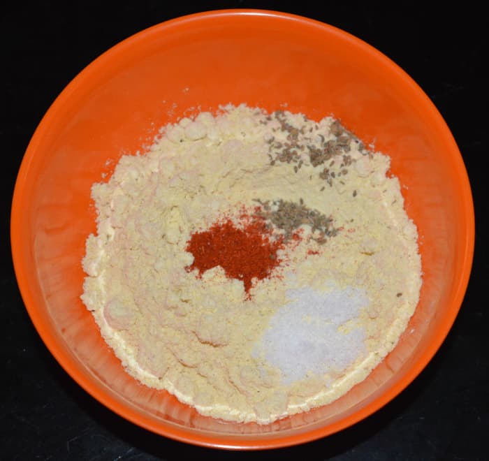 1. Add chickpea flour, red chili powder, salt, and carom seeds to a mixing bowl. Add water little by little and prepare a thick and lump-free batter.