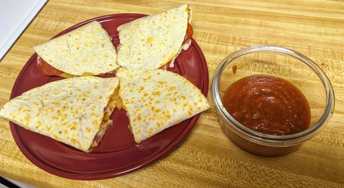 Pizzadillas can be cut into halves or quarters, and are best served with a side of sauce.