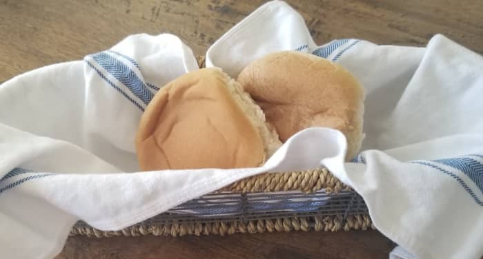 As a basket liner, a kitchen towel helps keep bread warm and provides eye appeal when displaying rolls.