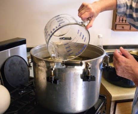 Pour into your pressure canner the recommended amount of water (usually 2 quarts), and begin heating it.
