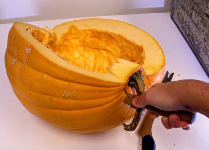 The more wedges you cut, the harder it may be to hold your pumpkin still. Engage another pair of hands if necessary. Scrape seeds into a waiting bowl as you complete each slice, but don't bother yet with "strings."