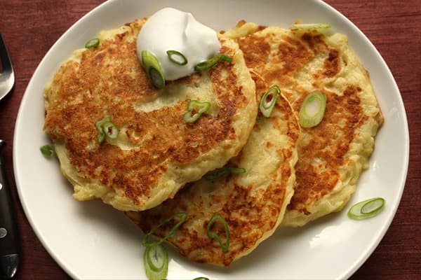 This is our favorite way to serve potato pancakes: with a little chopped green onion and sour cream.