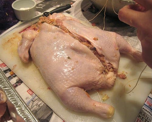 This chicken has been completely deboned, then filled with something fabulous, and is now ready to seal up and roast.