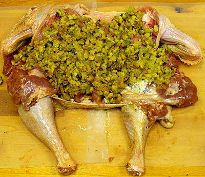 Turkey that's been deboned to use in a Turducken and stuffed. This one is ready to roll and seal for cooking.