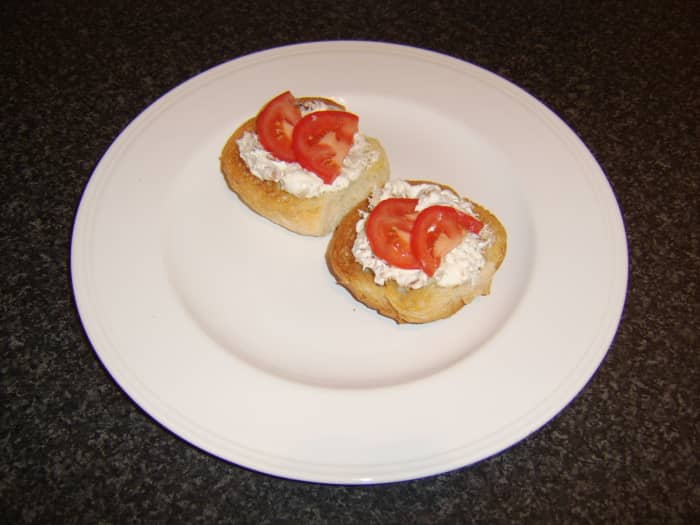 The smoked mackerel and soured cream is spread on the hot rolls and garnished firstly with a little bit of tomato