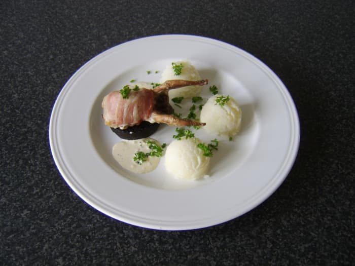 The quail is wrapped in bacon and roasted before being served on a slice of Stornoway black pudding with mashed potatoes and peppercorn cream sauce
