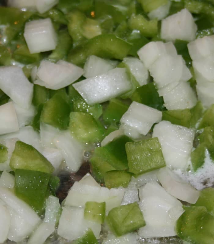 Sautee chopped onion and pepper in oil and let it cool before gently mixing it into the seasoned crab meat mixture.