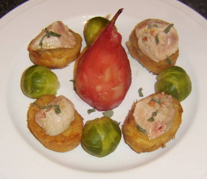 Pan fried partridge breasts are halved and served on fondant potatoes with a pear poached in cranberry juice centrepiece