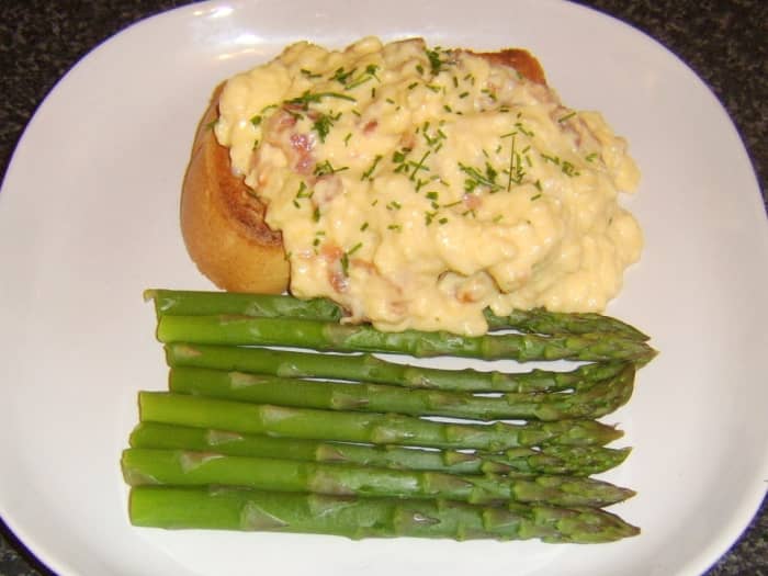 Smoked salmon is stirred through scrambled duck eggs which are served on toast and with steamed asparagus