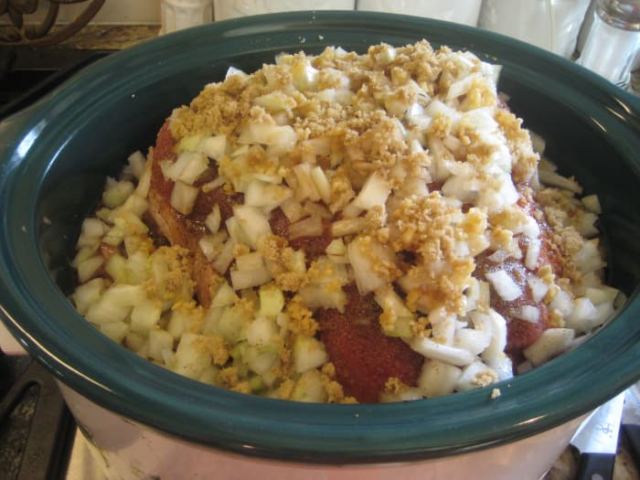 This little piggy is now sitting in beef broth and covered with onions, garlic, liquid smoke, and a bit of brown sugar. It's now time to put the lid on, turn the crock pot to low, and forget about it for eight hours.