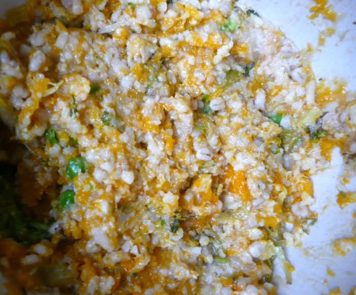Using a potato masher, mash the risotto until any large chunks of vegetables are broken up, and the mixture is fairly sticky.
