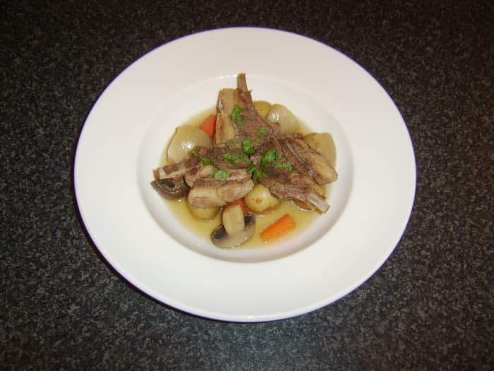 Casseroled lamb chops are laid on top of the root vegetables and garnished with freshly chopped mint
